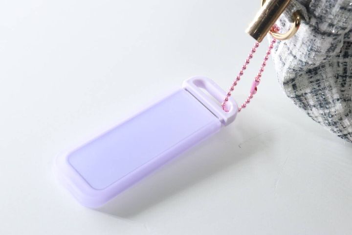 紫色のミラーにピンクのボールチェーンを付け、バッグの金具にぶら下げている