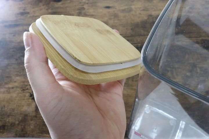 手で竹蓋付き保存容器の竹製の蓋を持ち、裏側の白いパッキンが見えるようにしている