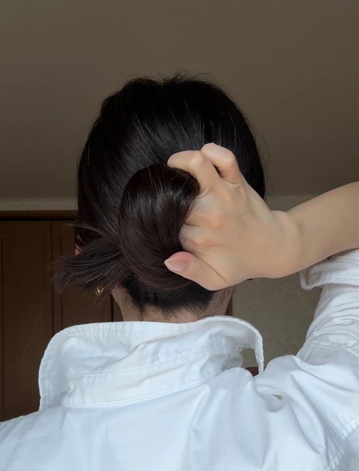 フレンチツイストの手順で、指2本に髪を巻き付けている様子