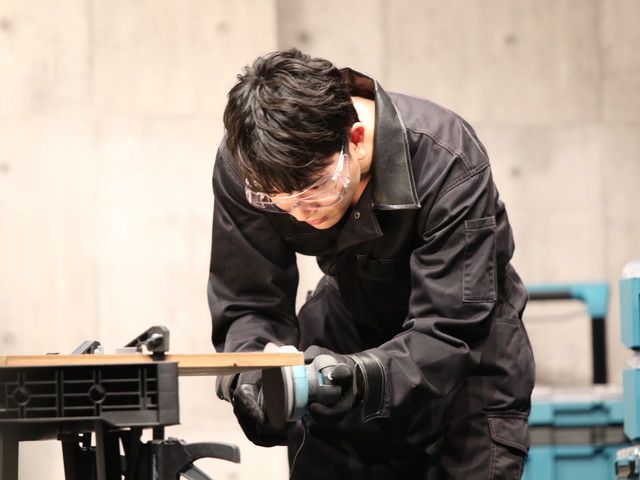 保護メガネをつけてサンダで木材を磨く髙地優吾さん