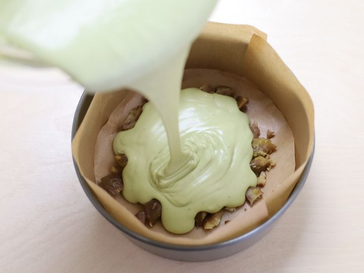 砕いた甘栗を敷いた型に抹茶チーズケーキの生地を流し入れた様子