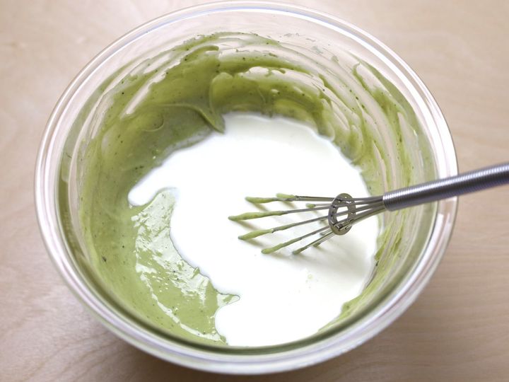 抹茶チーズケーキの生地に生クリームを加えて混ぜる様子