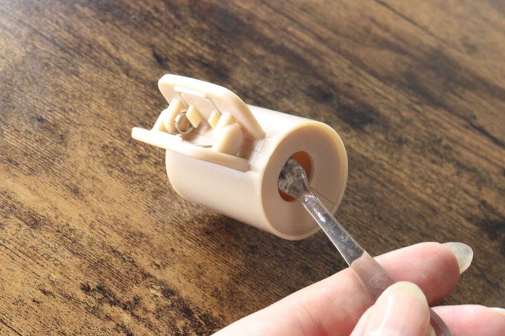 ベージュのクリップの穴に歯ブラシの柄を通している様子