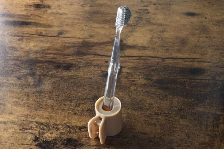 ベージュのクリップをスタンドとして使い、歯ブラシを立てている状態