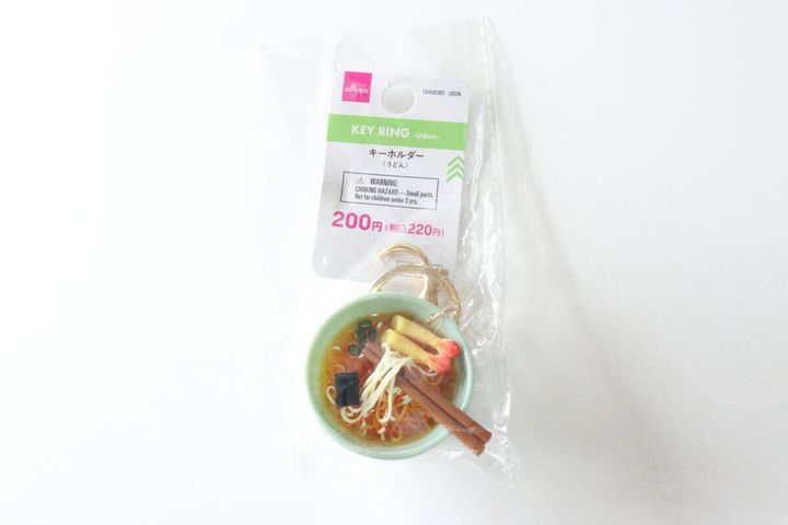 透明な袋に入ったダイソーのうどんキーホルダー。商品名と価格が記載されたパッケージ。