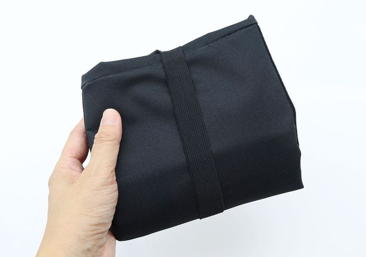 手のひらにコンパクトに折りたたまれた黒いトートバッグ