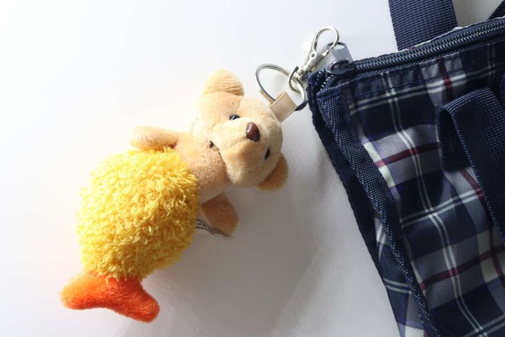 チェック柄のバッグにエビフライくまキーホルダーが付けられている様子