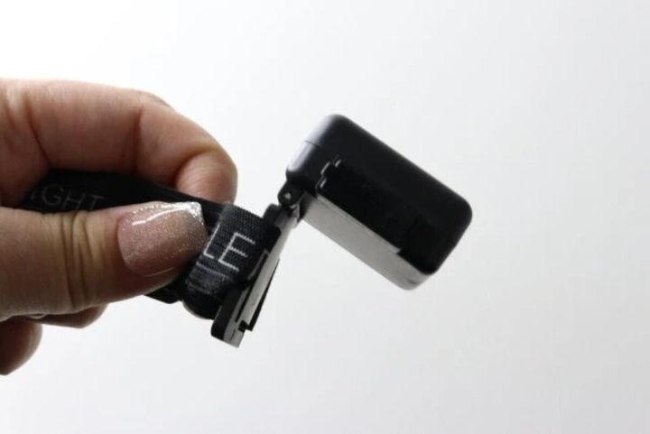 指でCOBヘッドライト本体を持ち、ライト部分を上に傾けて角度を調整している手元