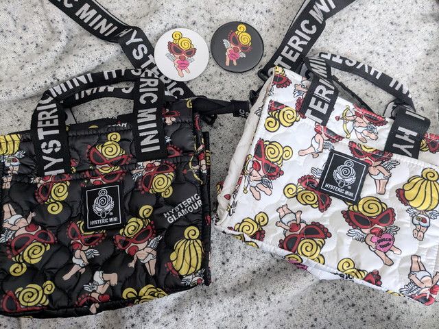 BLACK ver.とWHITE ver.のショルダーバッグと缶バッジを並べた全体写真