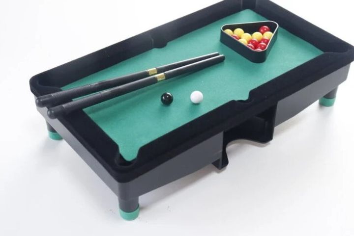 緑のフェルトが張られたミニビリヤード台に、キューとカラフルな球がセットされている