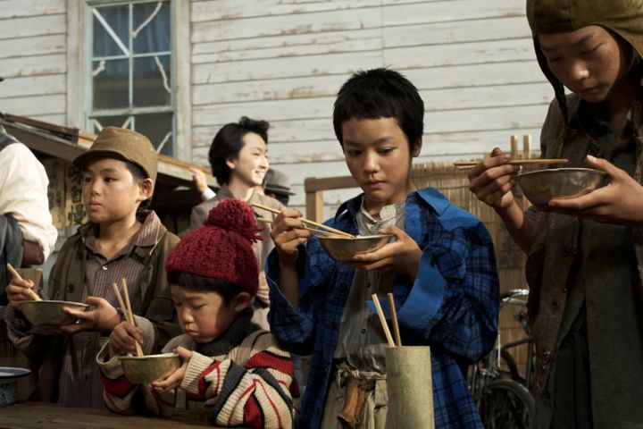 映画『わたしの知らない子どもたち』より琴子（小八重葵美）らが闇市で食事をする場面