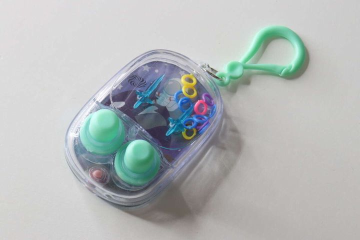 白い背景に置かれた、水色のボタンが付いた楕円形のミニウォーターゲーム機