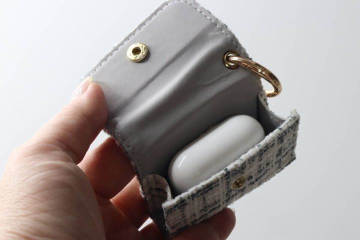 イヤホンケースの中に白いAirPodsケースがぴったり収まっている