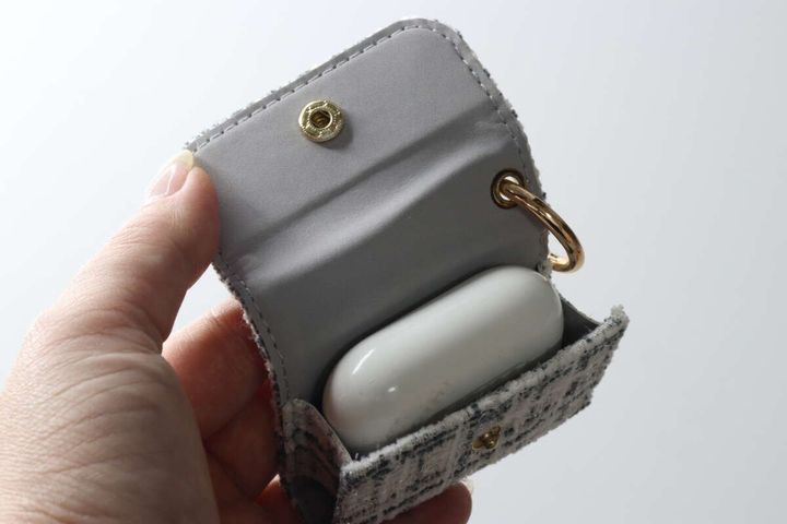 イヤホンケースの中に白いAirPodsケースがぴったり収まっている