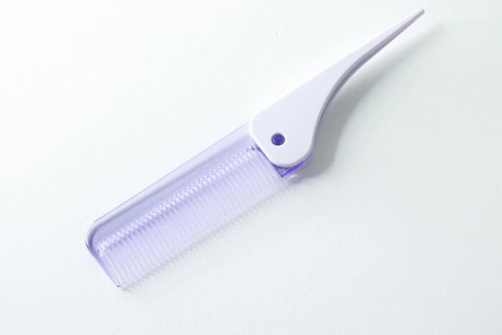 紫色の「サラサラストレートコーム」が完全に広げられた状態で白い背景に置かれている