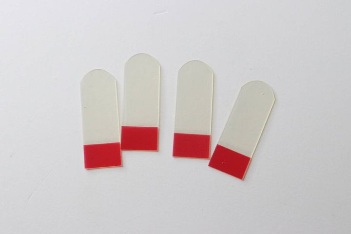 透明な伸びるテープ4枚が赤い保護フィルムを付けて並べられている