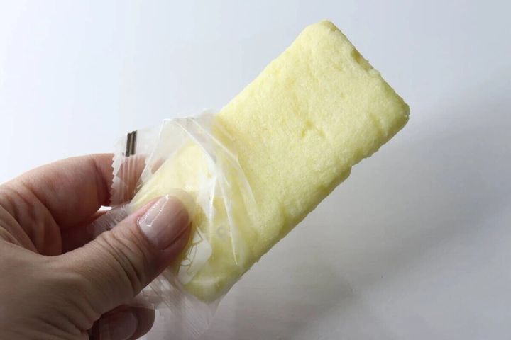 手がバナナ味ライスクラッカーの個包装を開けている