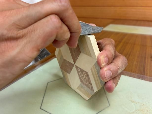 紙やすりは表裏だけでなく側面にも。まだ接着が不安定な場合があるため、パーツがずれないよう押さえながら磨こう