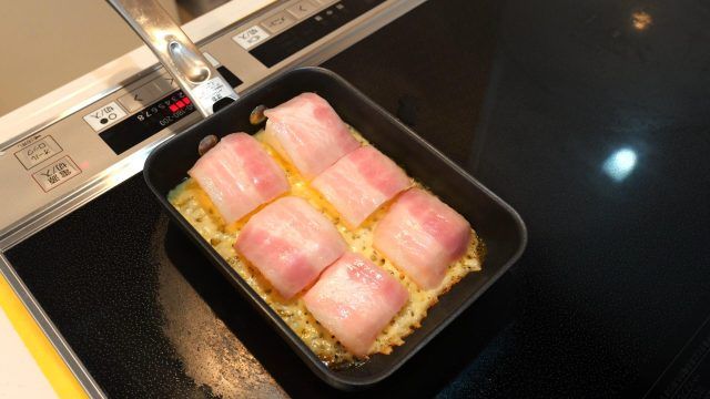 フライパンに並べたベーコン