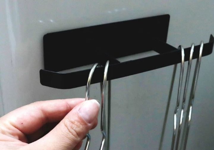 黒いマグネットハンガーに金属製ハンガーを掛ける手元
