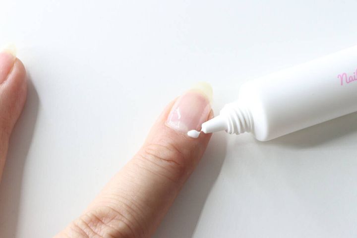 女性が指先にネイルケアクリームを直接塗布している様子