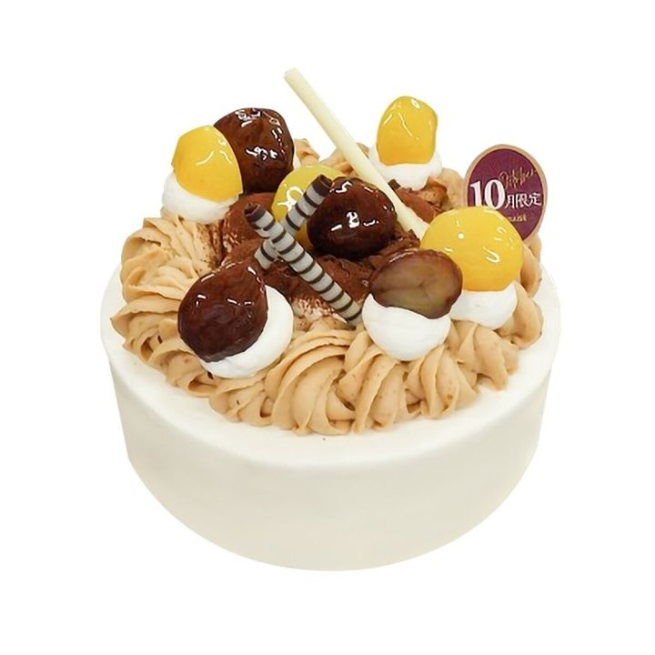 白い土台のデコレーションケーキ。栗クリームの上に渋皮栗や黄栗、チョコレートが飾られている。