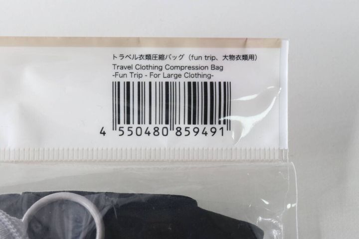 パッケージ上部のバーコードと「トラベル衣類圧縮バッグ (fun trip、大物衣類用)」の商品名がアップで写っている。