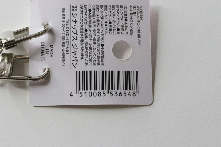 セリアの「Wナスカン チェーン付 推しハピ」のパッケージ裏面に記載された商品情報とバーコード
