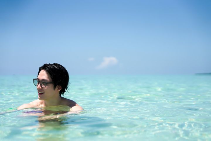 小浜島のエメラルドグリーンの海で泳ぐ男性のカット
