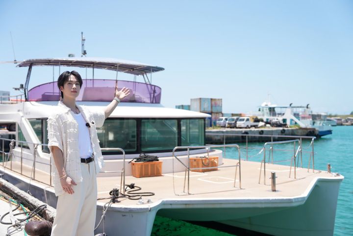 小浜島の港で船をバックにポーズを決めるTHE RAMPAGE 藤原樹さん 