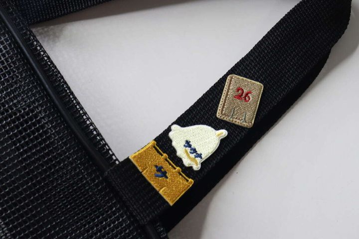 黒い銭湯バッグの持ち手にサウナモチーフのワッペン3個を貼ってデコレーションした様子