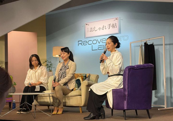 ステージでソファに座りマイクを持って話す3人の女性