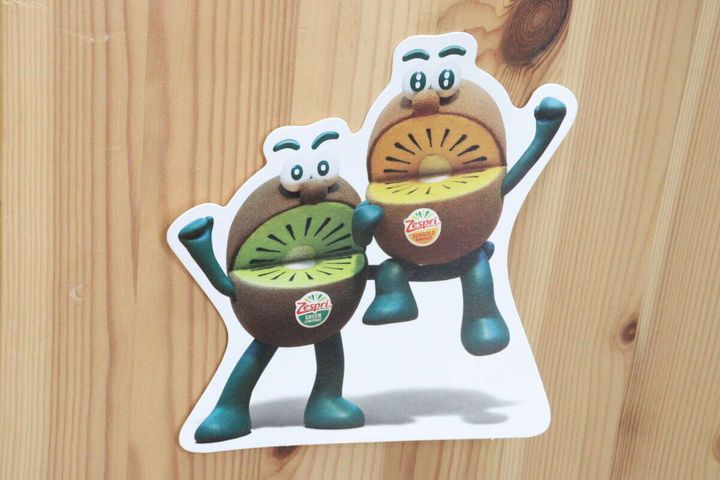 木目調の壁に、キウイのキャラクターが描かれたカードが透明なテープで貼り付けられている