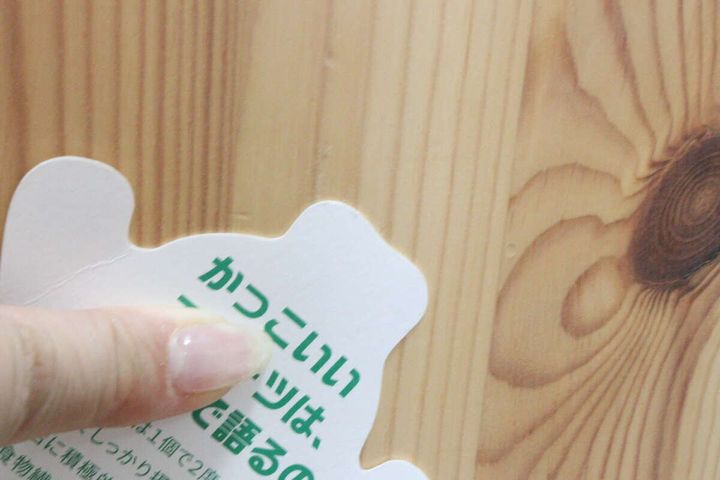木目調の壁からキウイのキャラクターカードを剥がした後、テープの跡が残っていない壁面