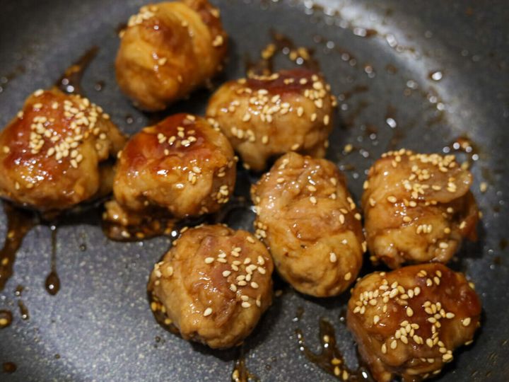 フライパンで照り焼きのタレが絡み、白いりごまが振られた豚こまボール