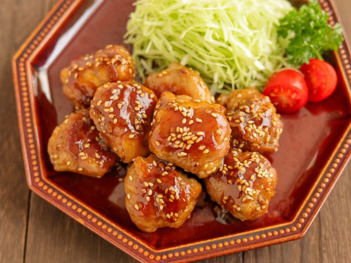 茶色い八角形の皿に盛り付けられた、豚こまボールの照り焼きと付け合わせの俯瞰