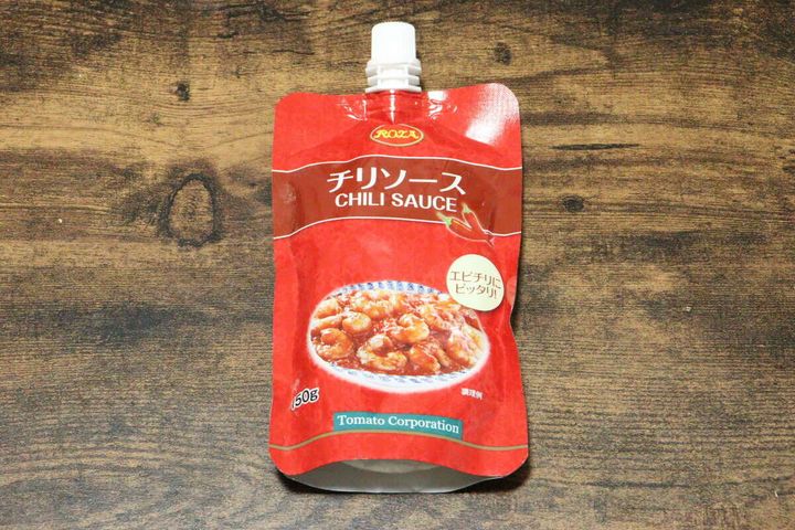 木目のテーブルに置かれた赤いパウチ容器のダイソーチリソース