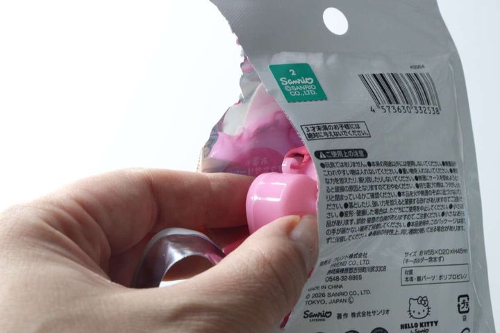 女性がマイメロディキーホルダーのパッケージを開封する様子
