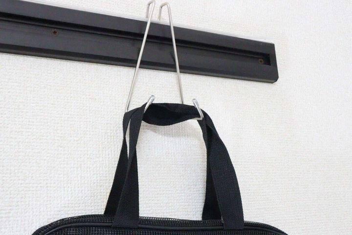 鴨居用便利フックに黒いトートバッグの持ち手を掛けている様子。