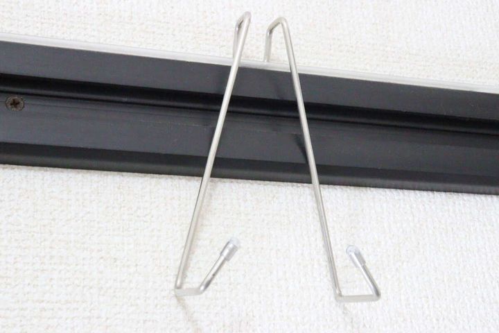 黒い鴨居にダイソー鴨居用便利フックを設置した様子。