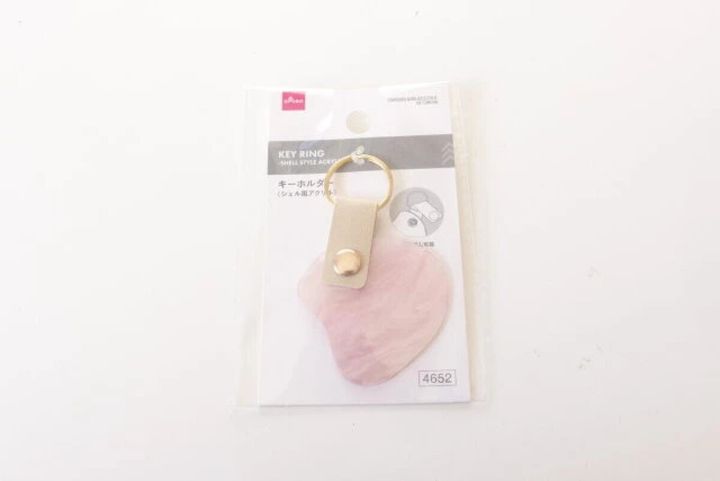 透明なパッケージに入った、ピンク色のシェル風アクリルキーホルダー