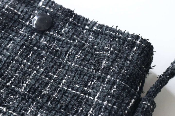 黒いツイード素材のショルダーバッグの生地の質感と黒いボタンのクローズアップ