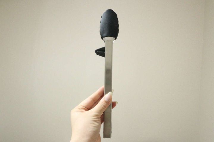 ロックされたシリコーントングの持ち手部分を女性の指が横から握っている