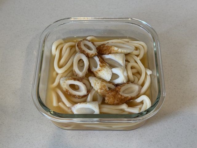 調味料を混ぜた耐熱容器にうどんとちくわを入れる