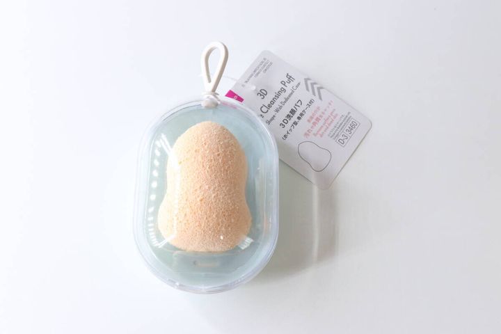 透明なケースに入ったひょうたん型の洗顔パフと商品タグ