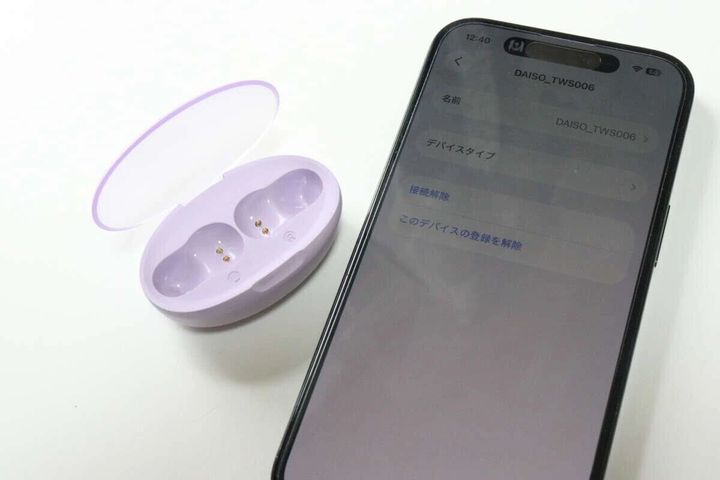 紫色のワイヤレスイヤホン充電ケースと、Bluetooth設定画面が表示されたスマートフォン