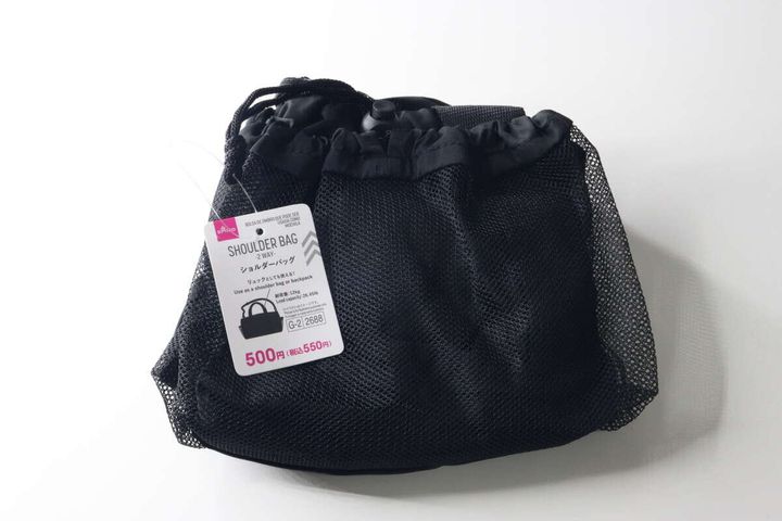 黒いメッシュ素材の巾着型バッグが畳まれ、商品タグが付いている様子