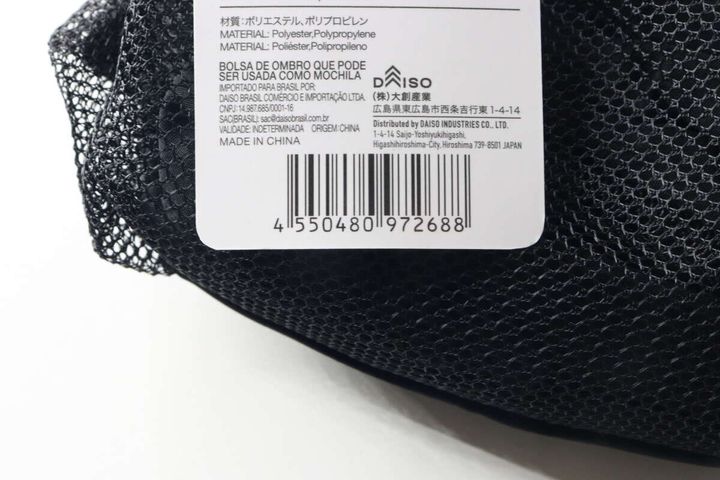 黒いバッグに付いた商品タグのアップで、JANコードや素材情報が見える