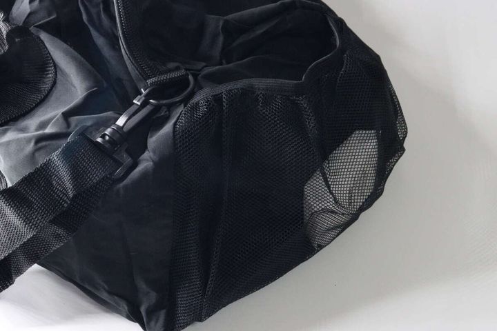 黒いバッグの口ゴムタイプのサイドポケットが空の状態で写されている