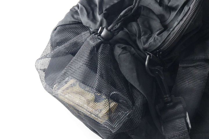 黒いバッグのサイドメッシュポケットに小銭入れのような小物が入っている